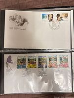 Both first day covers in plastic sleeve, showing stamps and cachets