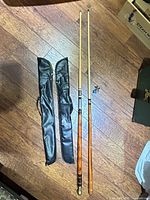 Two assembled cues with cases and accessories