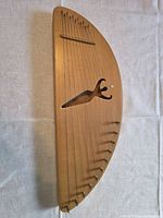 Front view showing 12 strings, tuning pins, bridge pins, carved soundhole