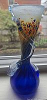 Full view showing entire vase, cobalt base, twisted stem, multicolor top