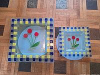 large and medium square plates with floral motif and checkerboard rim