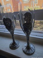 Front view of both pewter-based champagne flutes on windowsill
