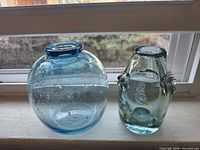 Front view of round vase and bottle showing color and size