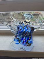 Front view showing multicolored glass body, wings, halo