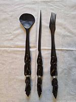 Full view of spoon, knife and fork on white cloth