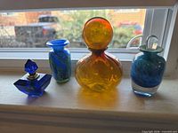 All four glass pieces lined on windowsill