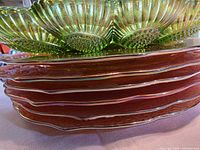 Stack showing green deviled egg tray atop marigold plates