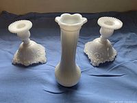 Front view of vase and both candle holders on blue cloth