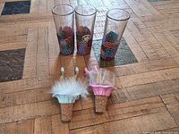 Three psychedelic shooter glasses and two novelty wine stoppers displayed on wood floor