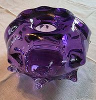 Full view of purple glass bowl underside showing lobes, opening and signature area