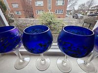 Four cobalt blue balloon-bowl goblets lined on windowsill