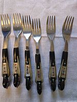 Front view of six forks showing handles and tines