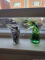 Both blown glass figurines side by side on windowsill