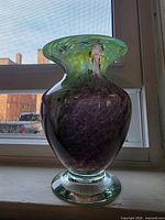 Front view of signed iridescent mottled art glass vase showing colors and shape