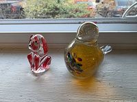 Front view of glass dog figurine and amber bird paperweight