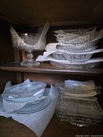 Pedestal compote and stacked oval bowls on shelf