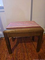 front angled view of bench showing wood frame and striped upholstered seat