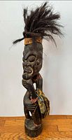 Full view of carved wood Fang guardian figure with fiber hair and cloth wrap