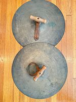 Full view of both handheld cymbals showing handles and straps