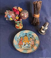 Group shot showing plate, tin mug with contents, twig bundle, small mask