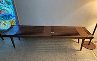 Full view of slatted wooden bench showing overall design and legs