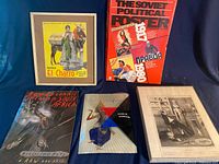 Group shot showing framed El Charro menu, Soviet poster book, Alcoa packet, Sue Coe book, framed magazine page