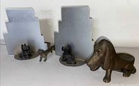 All four items side by side: two Scottie dog bookends, small dachshund, Ronson basset pipe holder