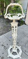 Full view of wrought iron pedestal ashtray holder showing handle, dish, column and base