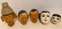 Front view of five vintage puppet heads showing size, style and wear