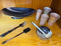 Overview of horn platter, horn utensils, small horn bowl with spoon, and four stone tumblers