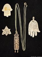Overview of all five jewelry pieces on black background