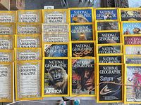 Assorted National Geographic magazines laid out, older text-cover issues left, modern photo-cover issues right