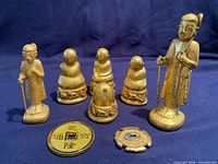 Group shot of all figurines, coin, ornament and tsuba