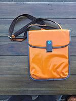 Front view of orange crossbody bag with strap