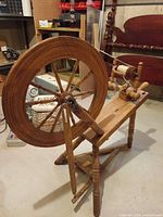 Full view of spinning wheel showing frame, drive wheel and legs