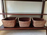Three matching woven rectangular baskets on shelf