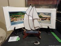 Group shot of stained glass sailboat, two Claude Pitcher prints, pewter sailboat