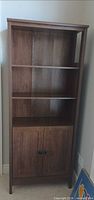 full view of tall wood veneer cabinet/bookshelf with shelves and doors