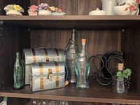 Shelf view showing metal lunch pails, fish bottles, Coca-Cola bottle, wine rack, small decorated bottle
