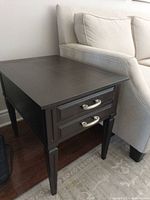 Full view of end table beside sofa showing two drawers and overall design