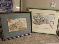 Two framed prints leaning against wall showing full view