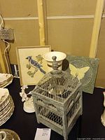 Group shot showing bird cage, wall plaques, hummingbird figurine and Hull vase