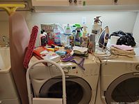 Overview of supplies on washer: iron, chemicals, cloths, extinguisher