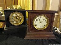 Front view of both mantel clocks showing cases and dials