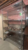 Full view of chrome wire shelving unit with six shelves and casters