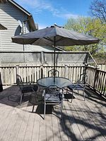 Complete patio set showing table, four chairs and umbrella opened