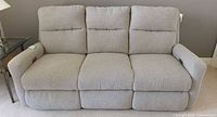 Front view of three-seat light grey fabric power reclining sofa