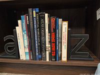 Shelf showing all fifteen books between black faux-leather “a” and “z” bookends