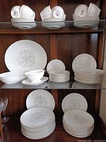 Cabinet display of full set including cups, saucers, plates, bowls and platter
