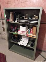 Full view of olive green open-front Steelcase cabinet with contents for scale